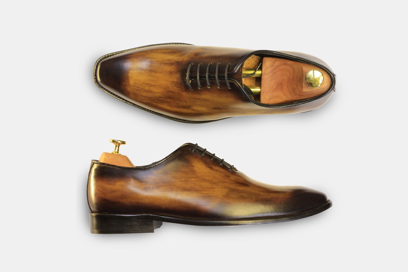 Brown leather dress shoes arranged on a light background